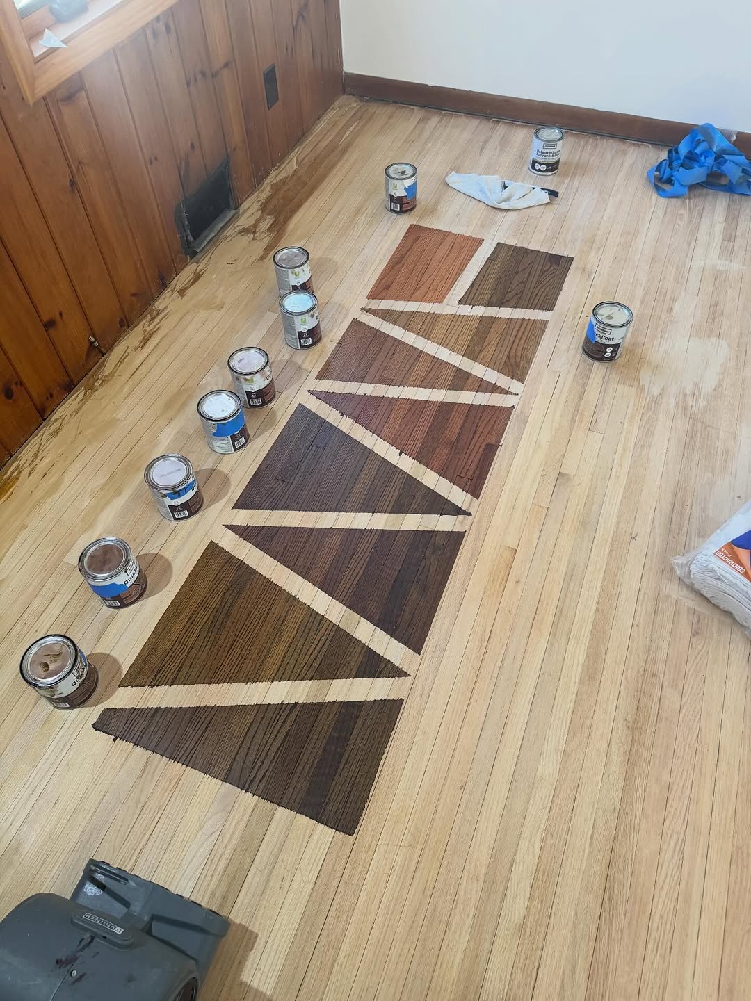Hardwood stain sample swatches on a floor by Detail Refinishing